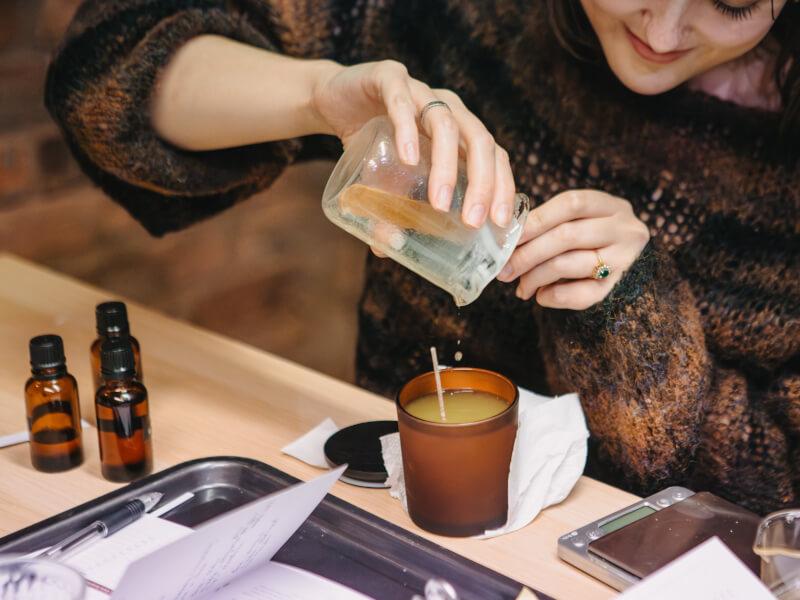 A participant pouring wax into a candle during a workshop